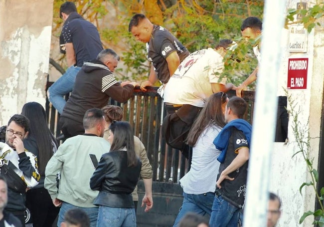 Aficionados saltando la puerta del acceso oeste al estadio.