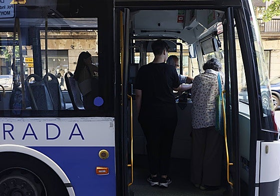 Dos viajeros subiendo a un autobús metropolitano.