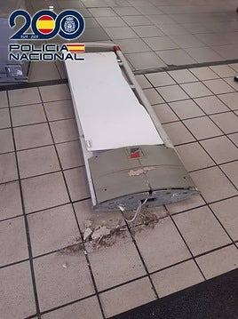 Imagen del panel de la entrada de la tienda destrozado.