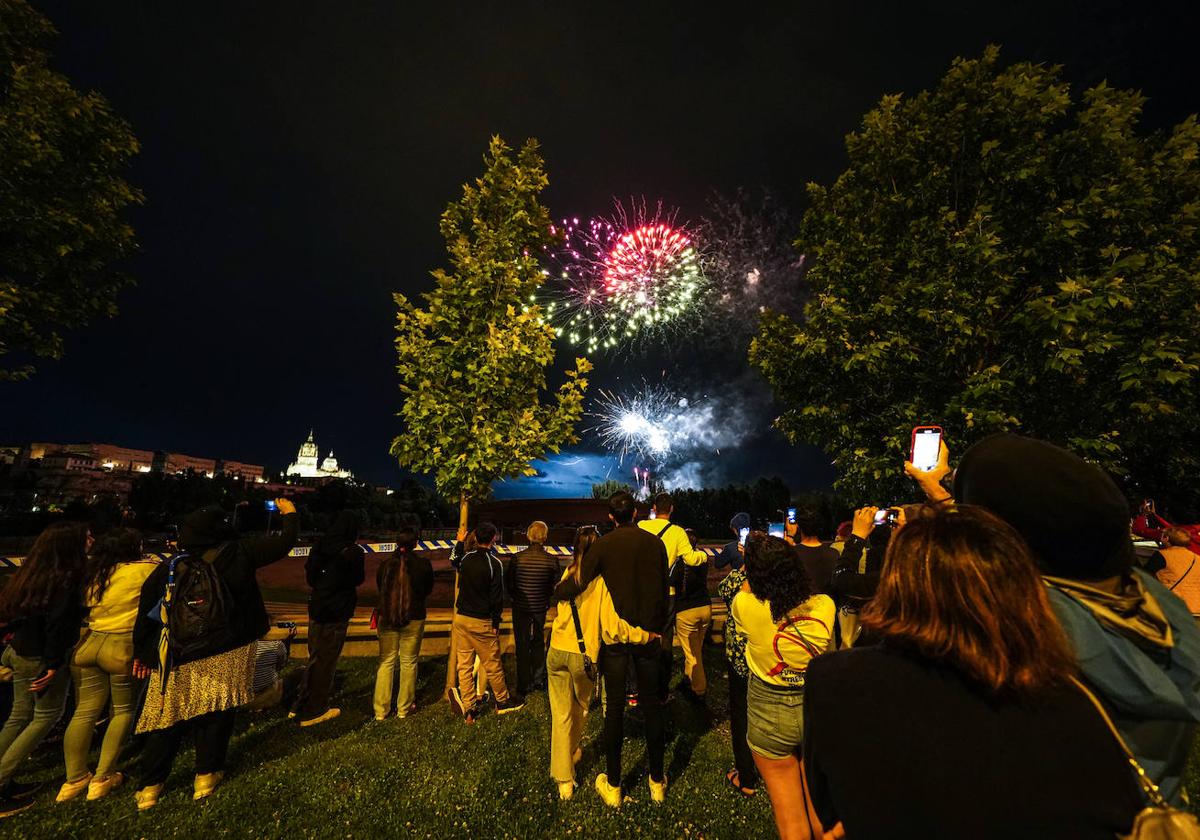 Algunos salmantinos, en los aledaños del Puente Romano, viendo los fuegos artificiales lanzados con motivo de la festividad de San Juan de Sahagún.