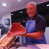 Un pescadero del Mercado coge un atún rojo.