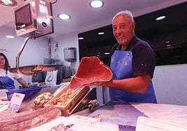 Un pescadero del Mercado coge un atún rojo.