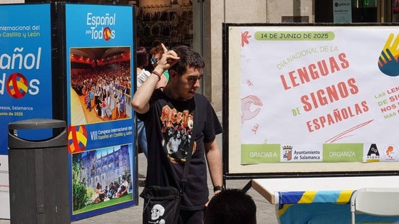 Un joven muestra a los asistentes cómo se deletrea su nombre en lengua de signos.