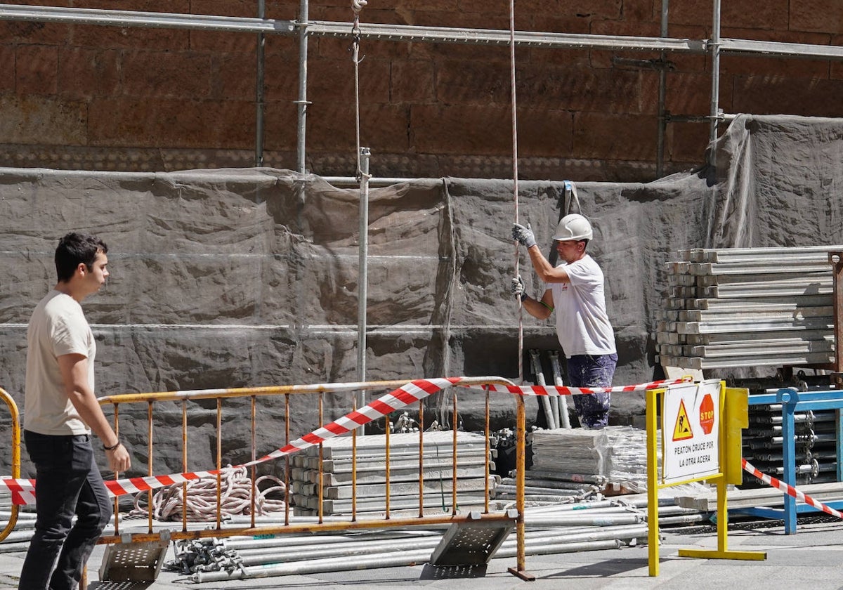 Un albañil monta un andamio en una obra en el centro de la capital.
