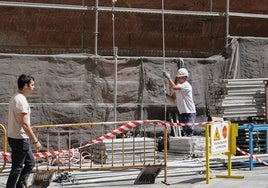 Un albañil monta un andamio en una obra en el centro de la capital.