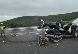 Un bombero junto al turismo accidentadp, que ha quedado completamente destrozado.