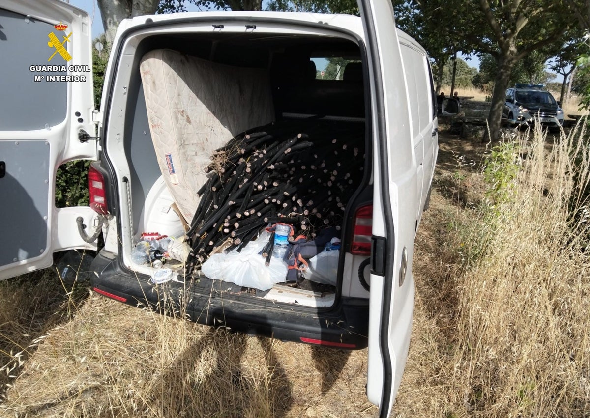 Imagen secundaria 1 - Agentes de la Guardia Civil junto a los detenidos y la furgoneta llena de cableado de cobre intervenido.