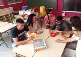 Un grupo de antiguos alumnos prueba a sentarse en los pupitres que utilizaban de niños.
