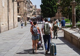Turistas cargados con sus maletas en la plaza de Anaya este domingo.