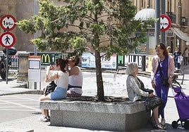 Viandantes protegidas en la sombra en la plaza de Santa Eulalia de Salamanca.