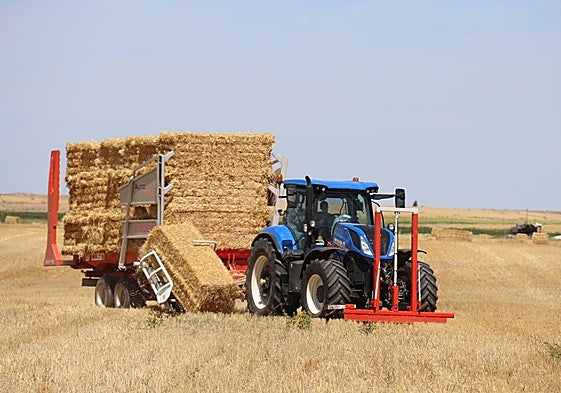 Un agricultor transporta paja.