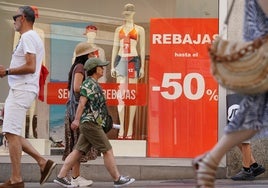 Varios grupos de personas pasean por una de las calles más comerciales de la ciudad.