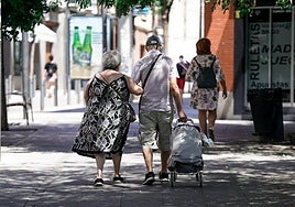 Una pareja de ancianos camina por la calle.