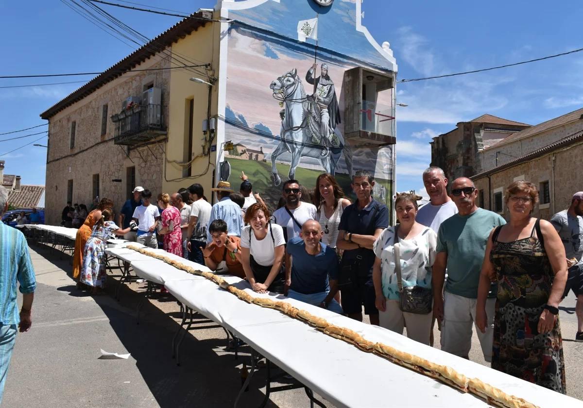 Algunos de los vecinos de Rollán, listos para degustar el megabocata de jamón que se ha repartido en la localidad en la tarde de este domingo.