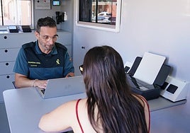 Un agente de la Guardia Civil atiende a una ciudadana en la Oficina Móvil de Atención al Ciudadano (OMAC).
