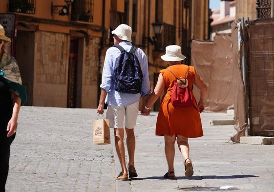 Dos personas pasean por el centro de Salamanca en un día caluroso.