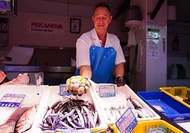 Un pescadero del Mercado de San Juan sostiene un puñado de almejas.