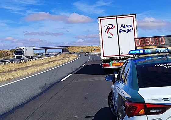 Una dotación de la Guardia Civil de Tráfico, junto al camión averiado, en la A-66.