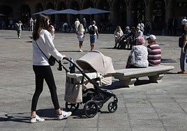 Una joven con un carro de bebé por la Plaza Mayor.