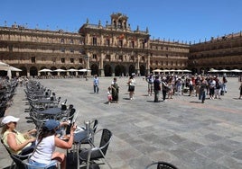 Turistas en la Plaza Mayor con las terrazas prácticamente vacías.