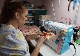 La costurera Diana Melón realizando unos arreglos en su taller en el barrio de Tejares.