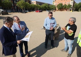 El alcalde, Carlos García Carbayo, y el concejal de Fomento, Fernando Carabias (primero y segundo por la izquierda), observan el plano de la urbanización del aparcamiento de El Zurguén.