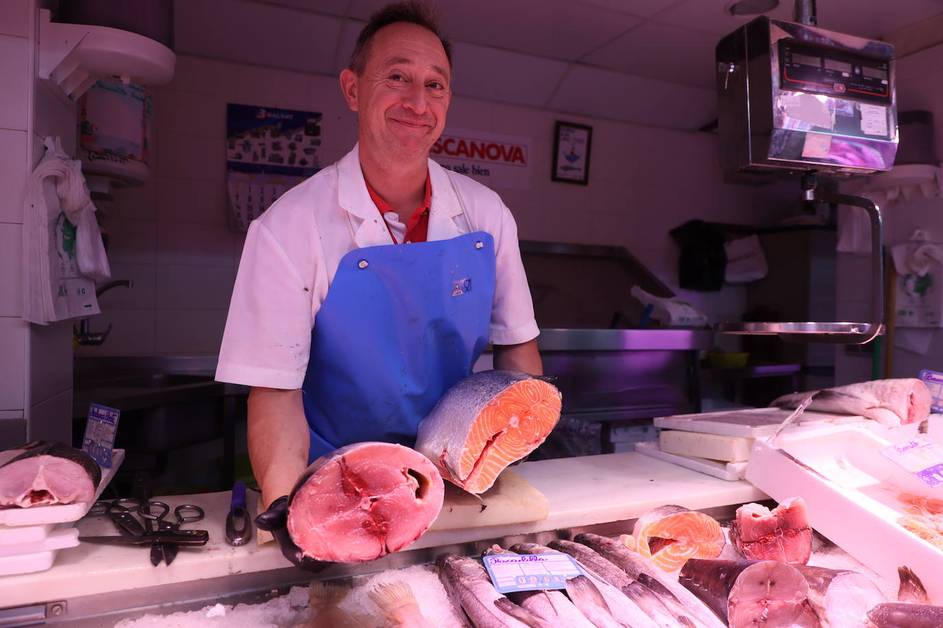 El pescadero Manuel López sostiene un salmón y un bonito.