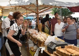 Varios visitantes de la Feria, en uno de los stands de dulces.