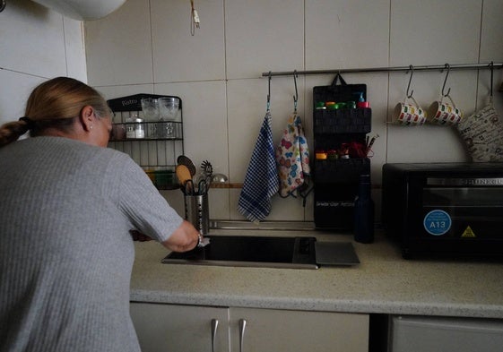 Pilar B., que prefiere ocultar su rostro, en la cocina de su pequeño apartamento.