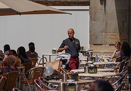 Un camarero, atendiendo mesas en una céntrica terraza.