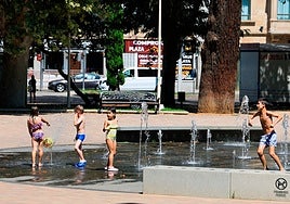 Dos niños y dos niñas, bañándose en la fuente de La Alamedilla.