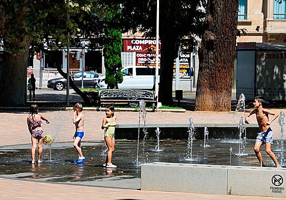 Dos niños y dos niñas, bañándose en la fuente de La Alamedilla.
