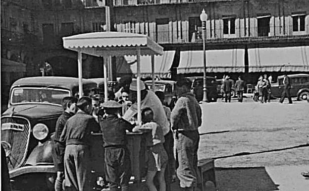 Un grupo de niños se arremolina alrededor del puesto de helados en la Plaza Mayor en los años 30.