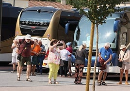 Viajeros bajando de autobuses en el centro de recepción de turistas.