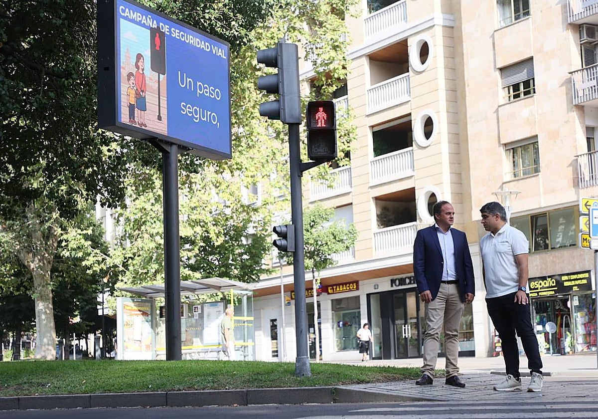 El concejal de Tráfico, Ángel Molina (izda.), junto a uno de los paneles con la imagen de la campaña de seguridad vial.