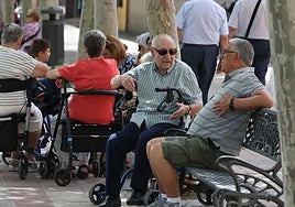 Mayores sentados en los bancos de una zona verde de Salamanca.