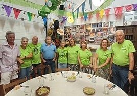 Algunos de los miembros de la peña La Cabra junto a la mesa antes de compartir la cena.
