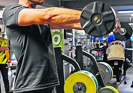 Una persona levantando unas pesas en el gimnasio.