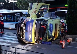 Los bomberos, trabajando en la ambulancia tras el vuelco.