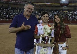 El ganadero Fernando García, de Adelaida Rodríguez, hace la venia al triunfador de la noche, Dani Alonso, en el centro con el trofeo.