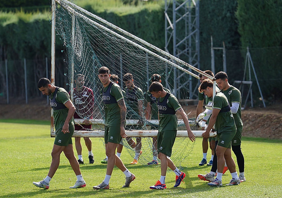 Los jugadores de Unionistas, con Pachón al frente, cargan una portería en el anexo al Tori.
