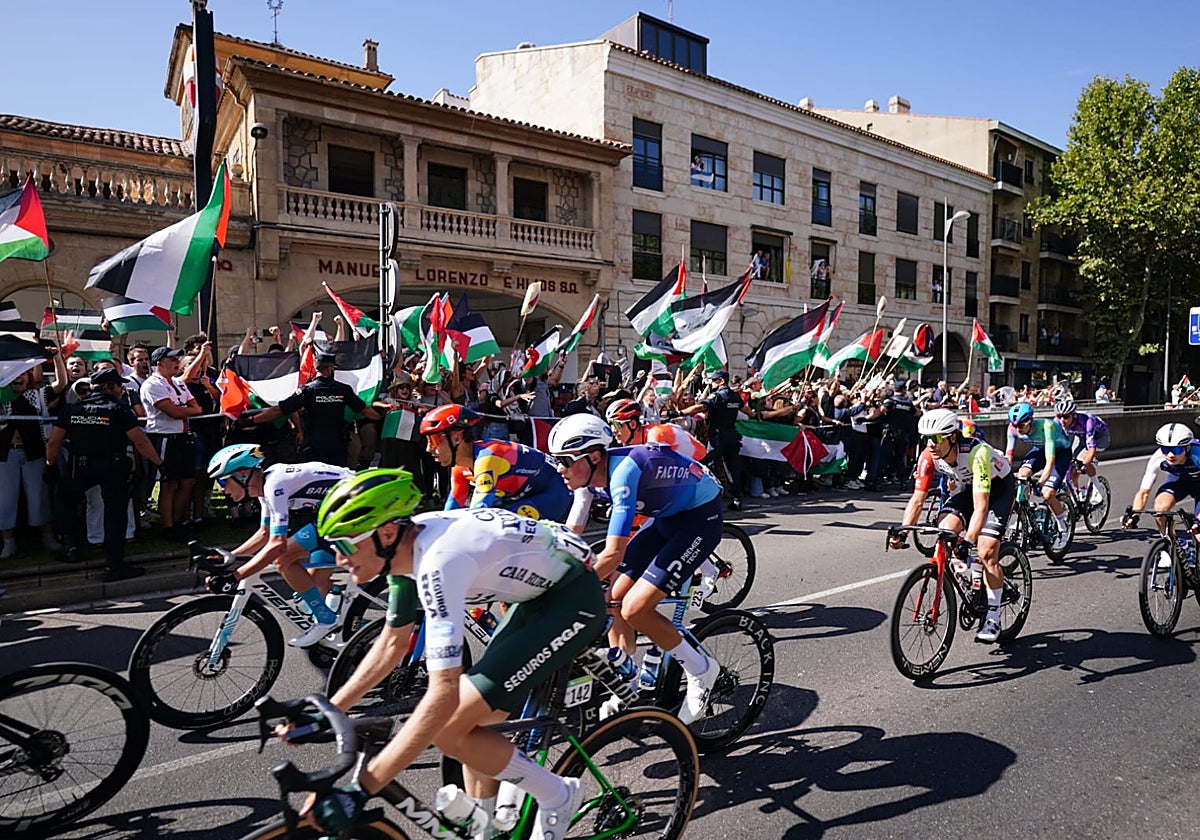Paso del pelotón por la avenida de los Reyes de España, junto a los protestantes pro Palestina y contra Israel.