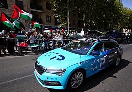 Uno de los coches del Israel - Premier Tech pasa junto a las protestas pro palestinas.