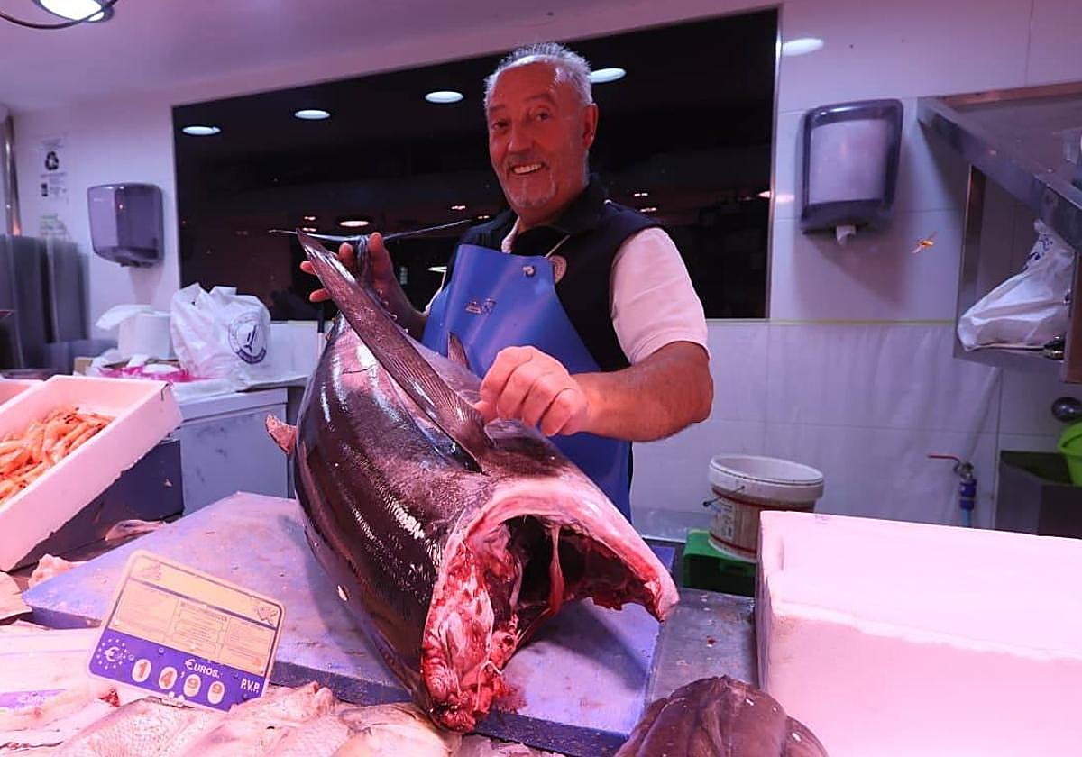 Un pescadero del Mercado, mostrando una de las piezas.