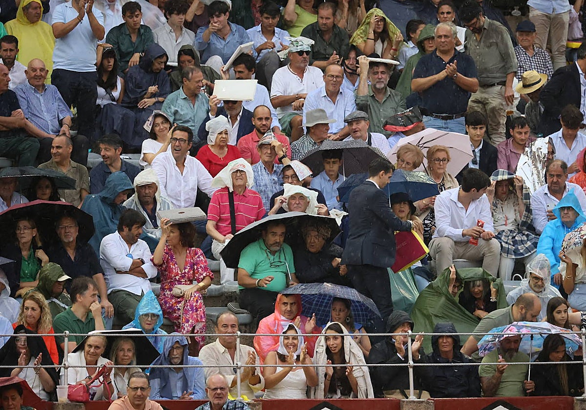 Los aficionados presentes, protegiéndose de la lluvia, en uno de los tendidos de La Glorieta.
