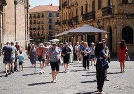 Un grupo de viajeros extranjeros junto a la iglesia de La Clerecía.