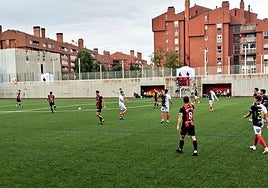 Jugadores de ambos equipos sobre el municipal de Gobela durante el encuentro.