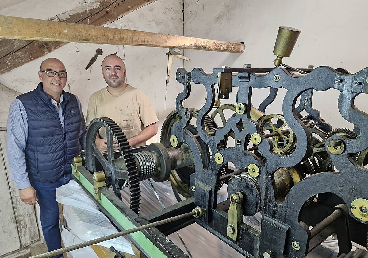 Ramón Sastre y Javier Merino junto al engranaje del reloj