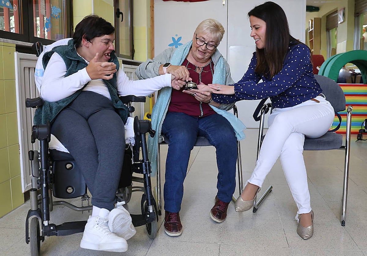 aola Alejo, su madre, Eugenia de Arriba, y Lidia García tocan un timbre, símbolo de la campaña de Aspace «Ya toca«.