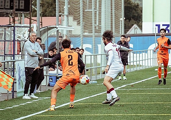 Mancebo trata de hacerse con un balón en la misma línea de banda, ante la presión de Abad.